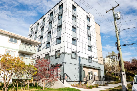 Illustration of a modular-style building next to an apartment building.
