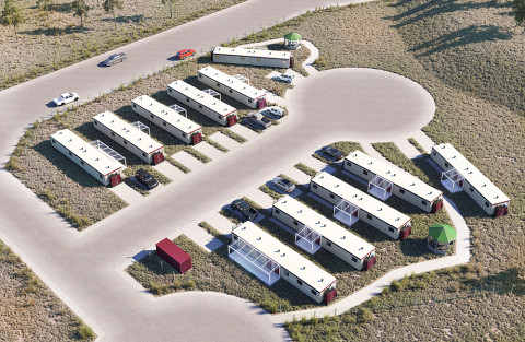 Aerial view of two rows of temporary modular white structures beside a road.