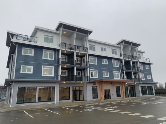 Four-storey apartment building located at 695 Aspen Street on a rainy day