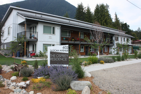 A two-storey building labelled ‘The Osprey Residence’ at 602 Slocan Ave, set against a backdrop of forested mountains.