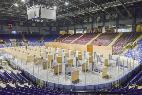 Temporary pods set up in rows on an arena floor.
