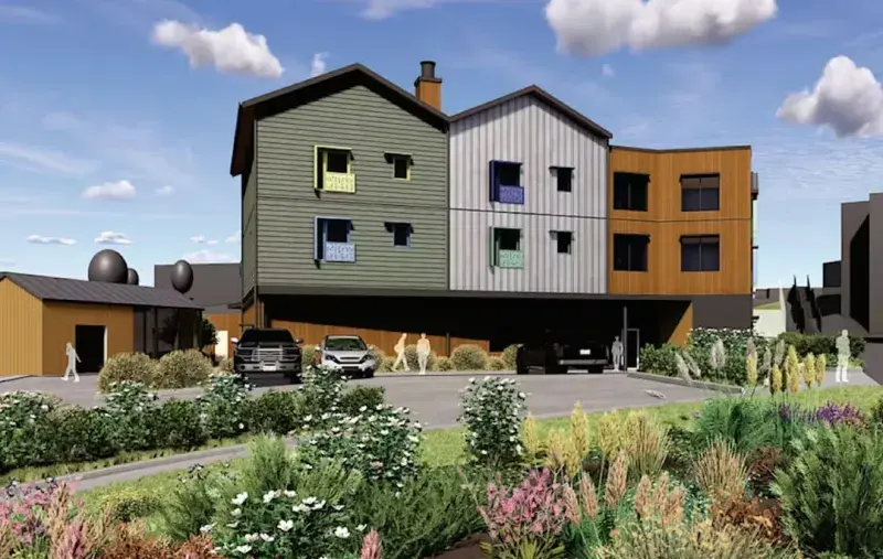 Architectural rendering of a three-storey residential building with varied coloured façades above a ground-level parking area, landscaped planting in the foreground, parked vehicles, and people walking along the site.