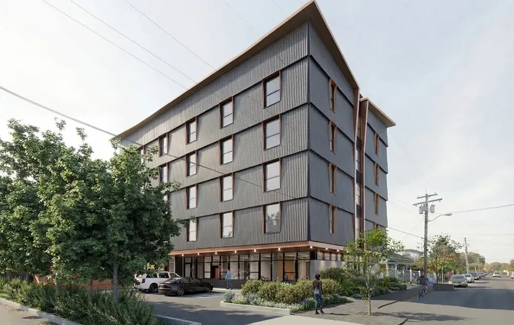 Architectural rendering of a five-storey supportive housing building with dark exterior panels, street-level landscaping, and sidewalks along a corner street.