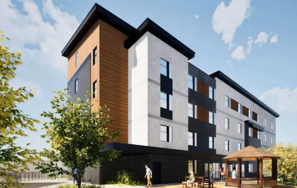 Illustration of a four‑storey apartment building with gray, white, and wood‑coloured walls. With trees, and a small seating area outside.